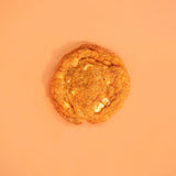 Pumpkin Spiced New York Cookie by Crumbs & Doilies with white chocolate and warm autumn spices on orange background